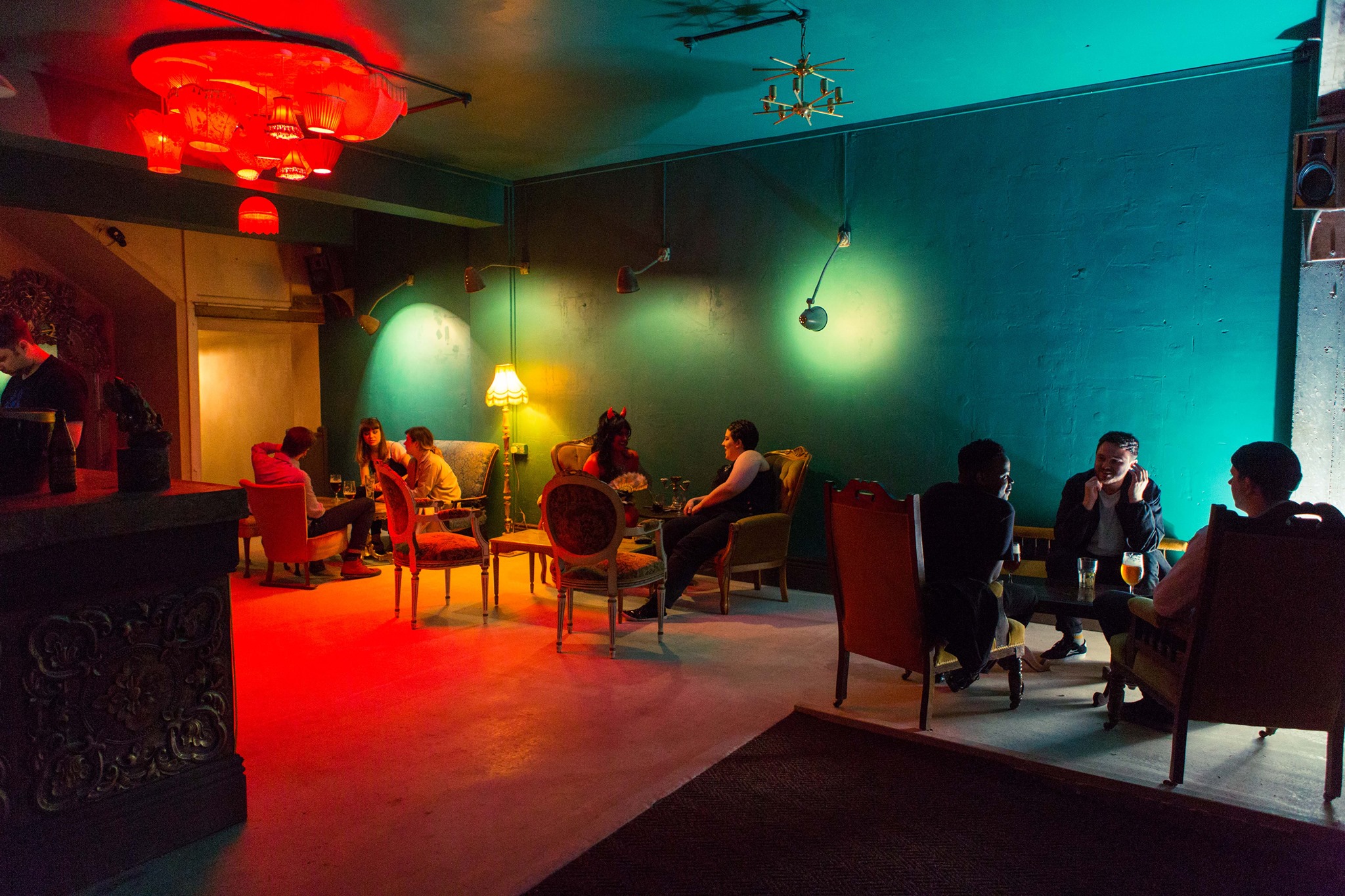 People sat round tables are enjoying drink in a bar.