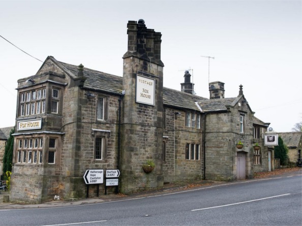 The exterior of The Fox House, a stone building with an impressive chimney stack.
