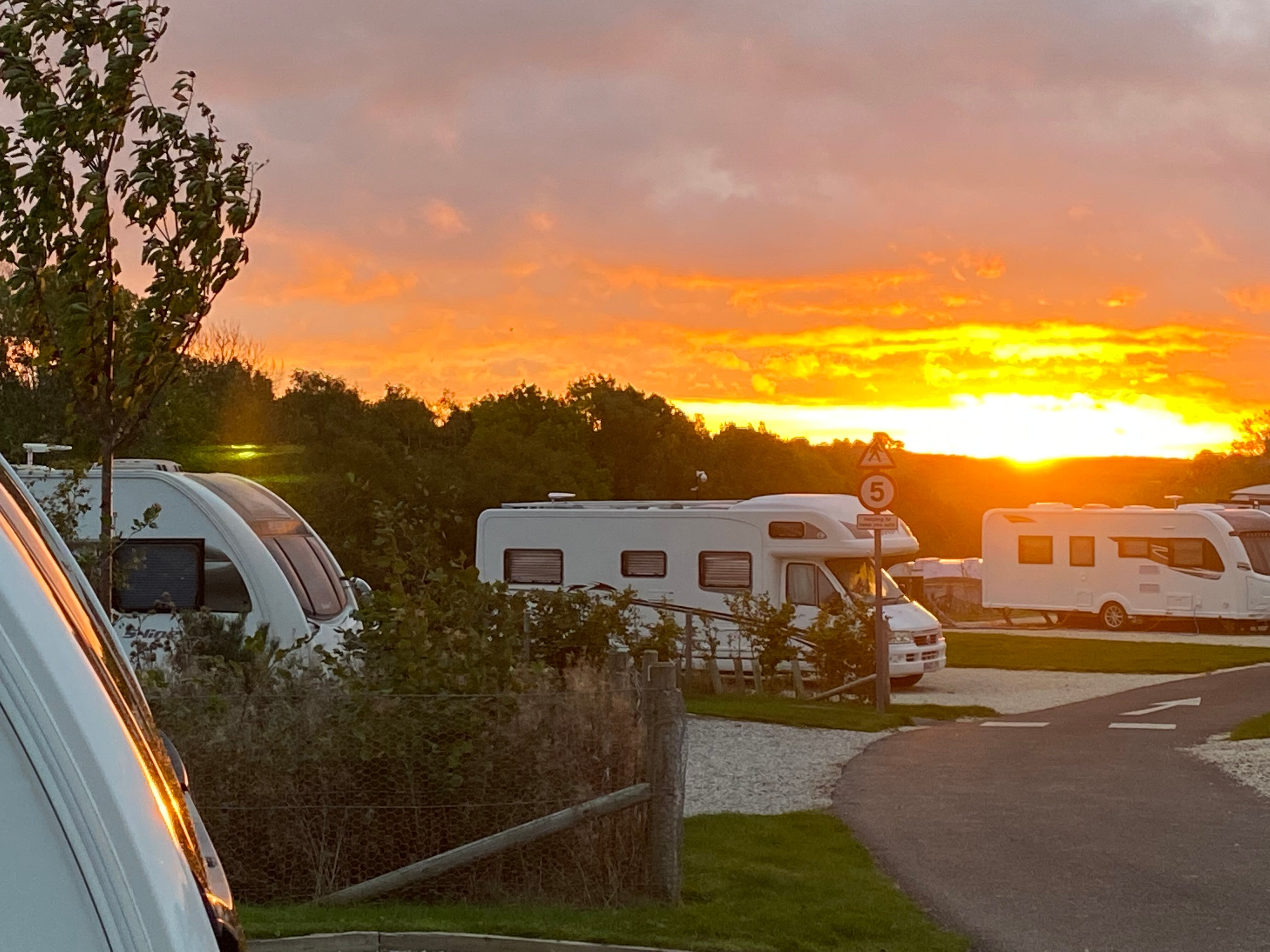 Sunset view over caravans at Waleswood Caravan and Camping Park with warm evening light