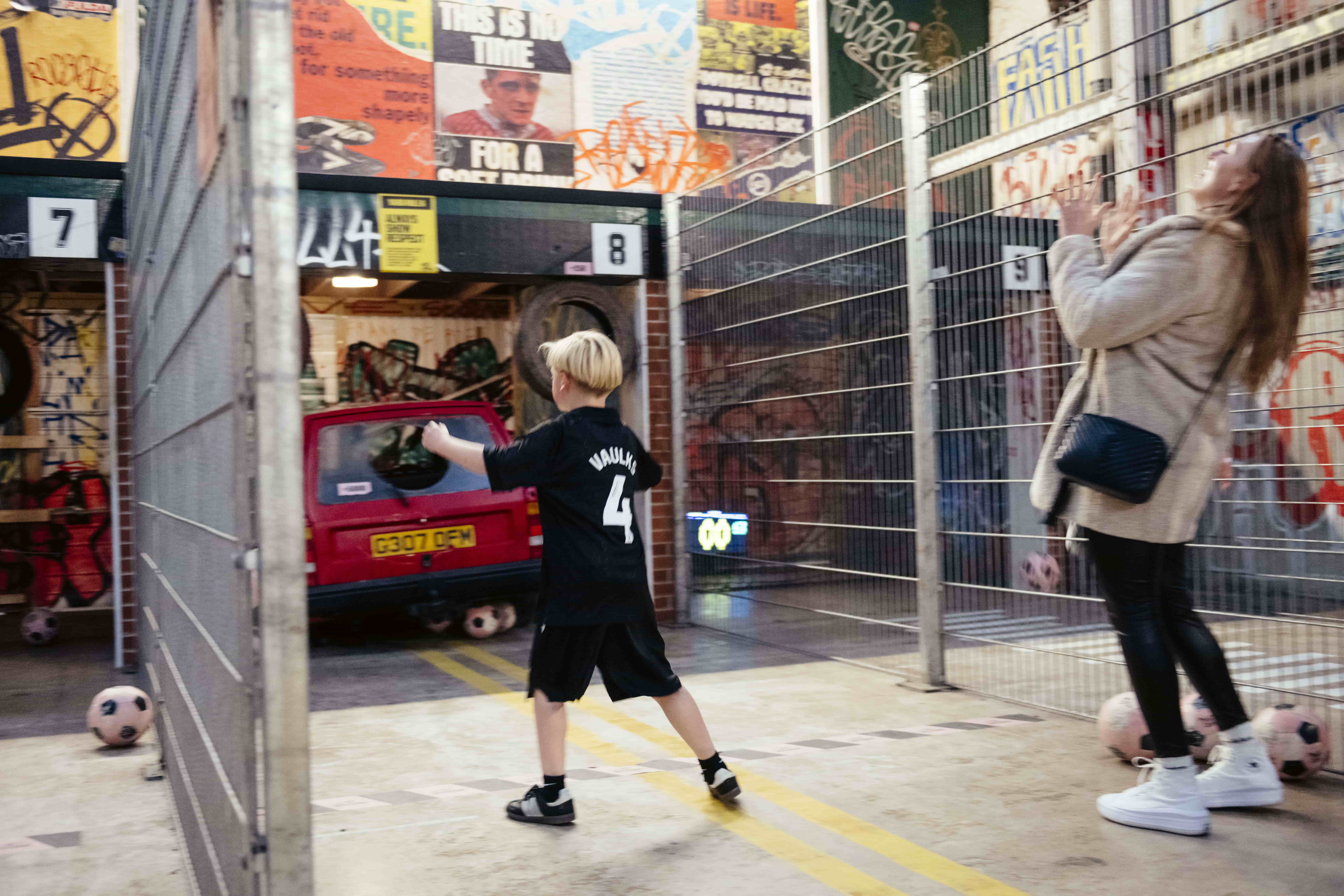 A woman and a boy playing football at Yard Ball.
