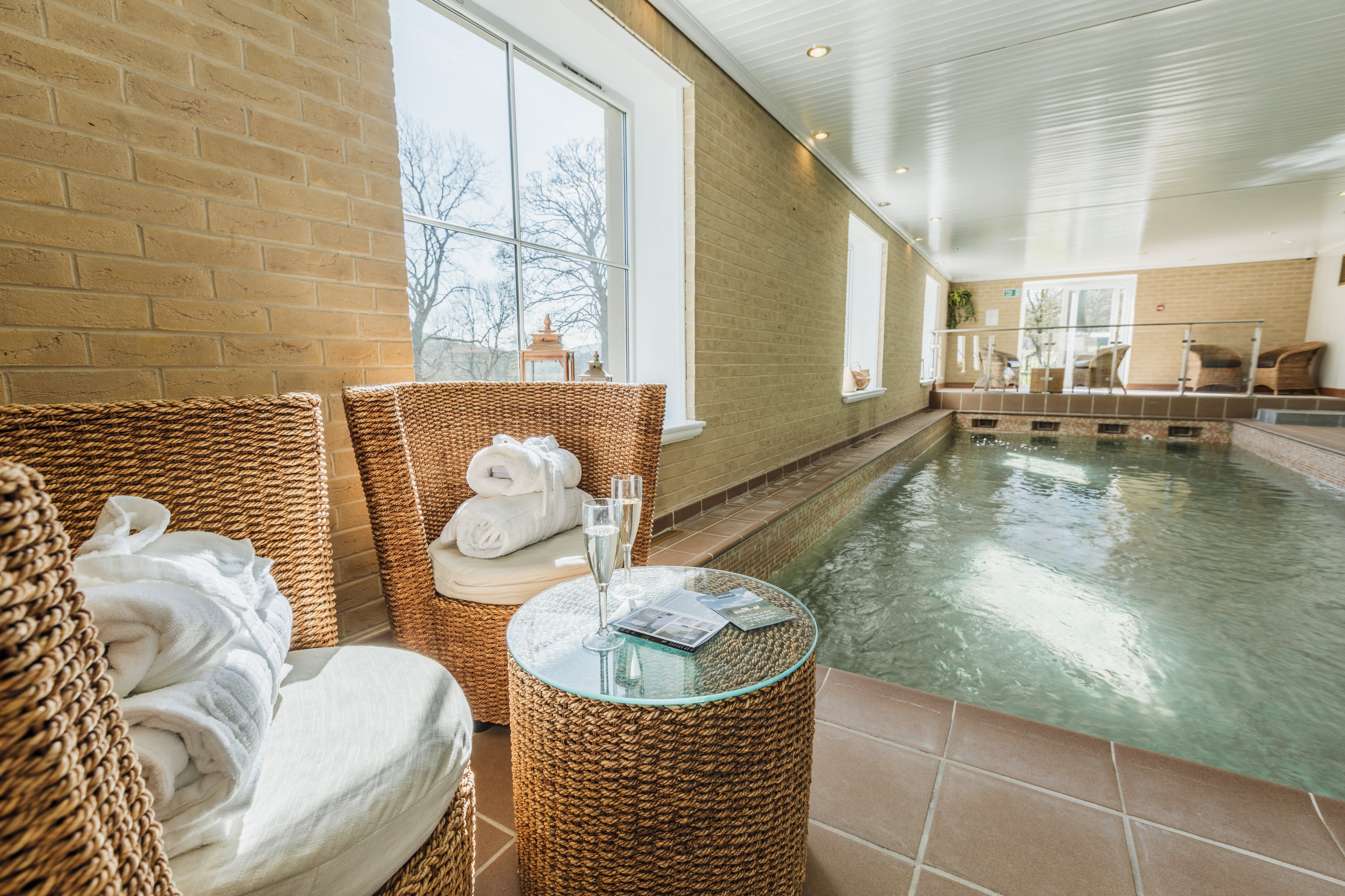 Indoor spa area at Losehill Hall Hotel featuring a swimming pool and relaxing seating.