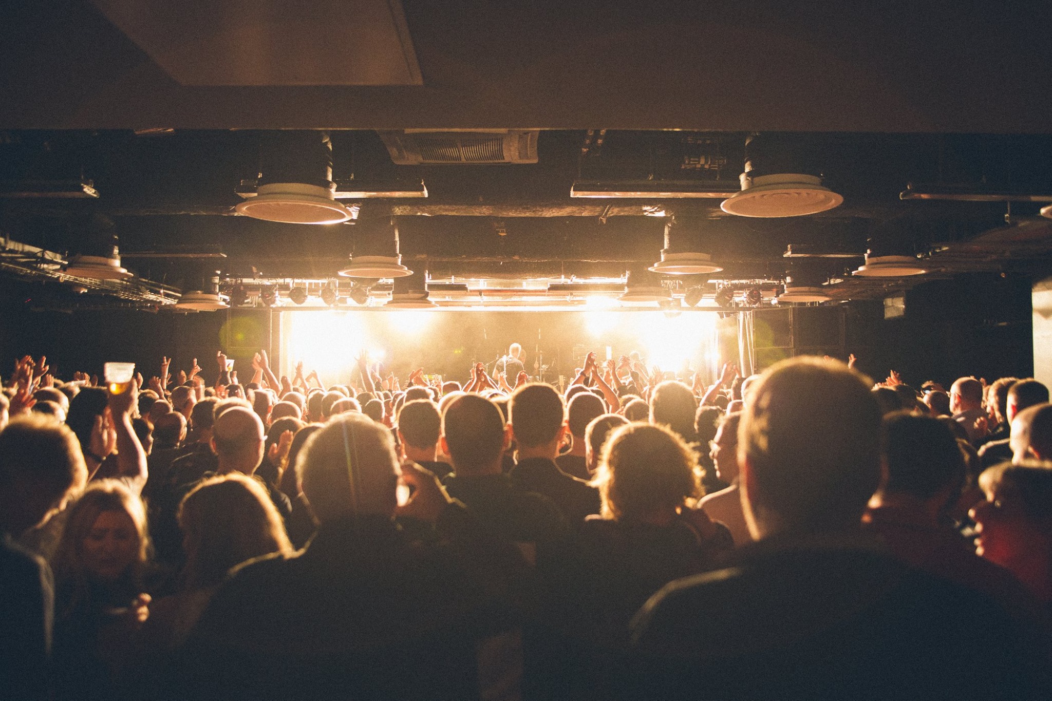 A crowd of people watching a band playing live.