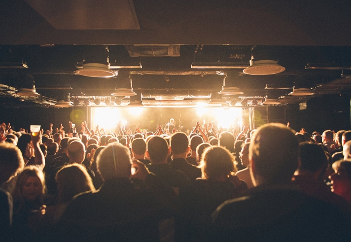 A crowd of people watching a band playing live.