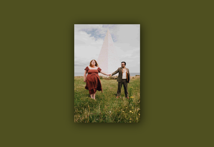 Will Finn and Rosie Calvert standing in a field in front of an obelisk.