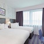 Bedroom featuring one double bed and one single bed, with modern furnishings.