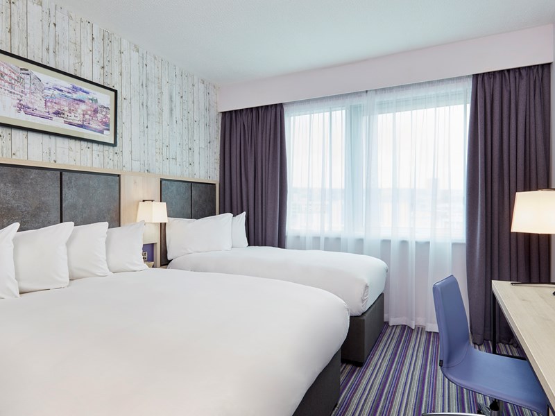 Bedroom featuring one double bed and one single bed, with modern furnishings.