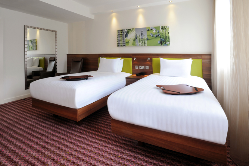 A hotel room with two single beds.