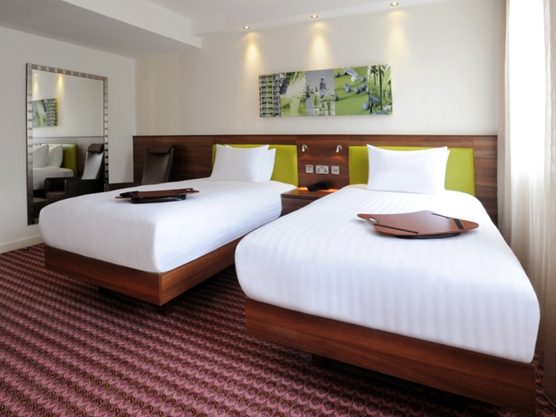 A hotel room with two single beds.