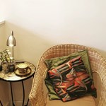 A wicker chair, with a coffee on a small side table, at the Dana Cafe.