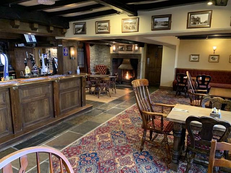 Rustic country inn bar with wooden furnishings, ambient lighting, and seating at Dog and Partridge.