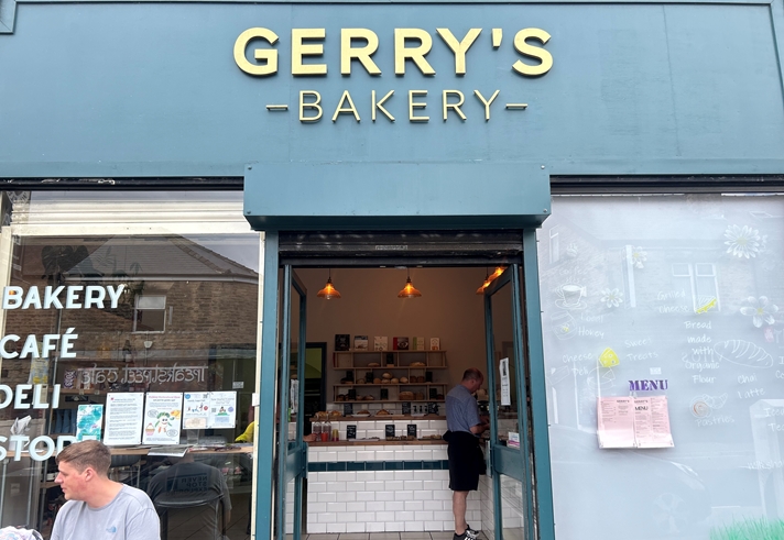 A photo of outside the the bakery, with the sign on top that reads Gerry's Bakery in gold letters