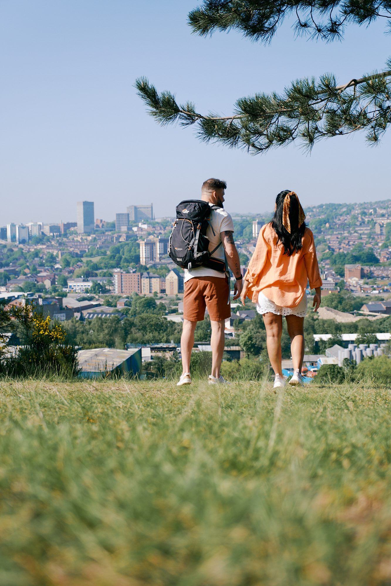Couple stand in front of a cityscape view of Sheffield from Parkwood Springs 