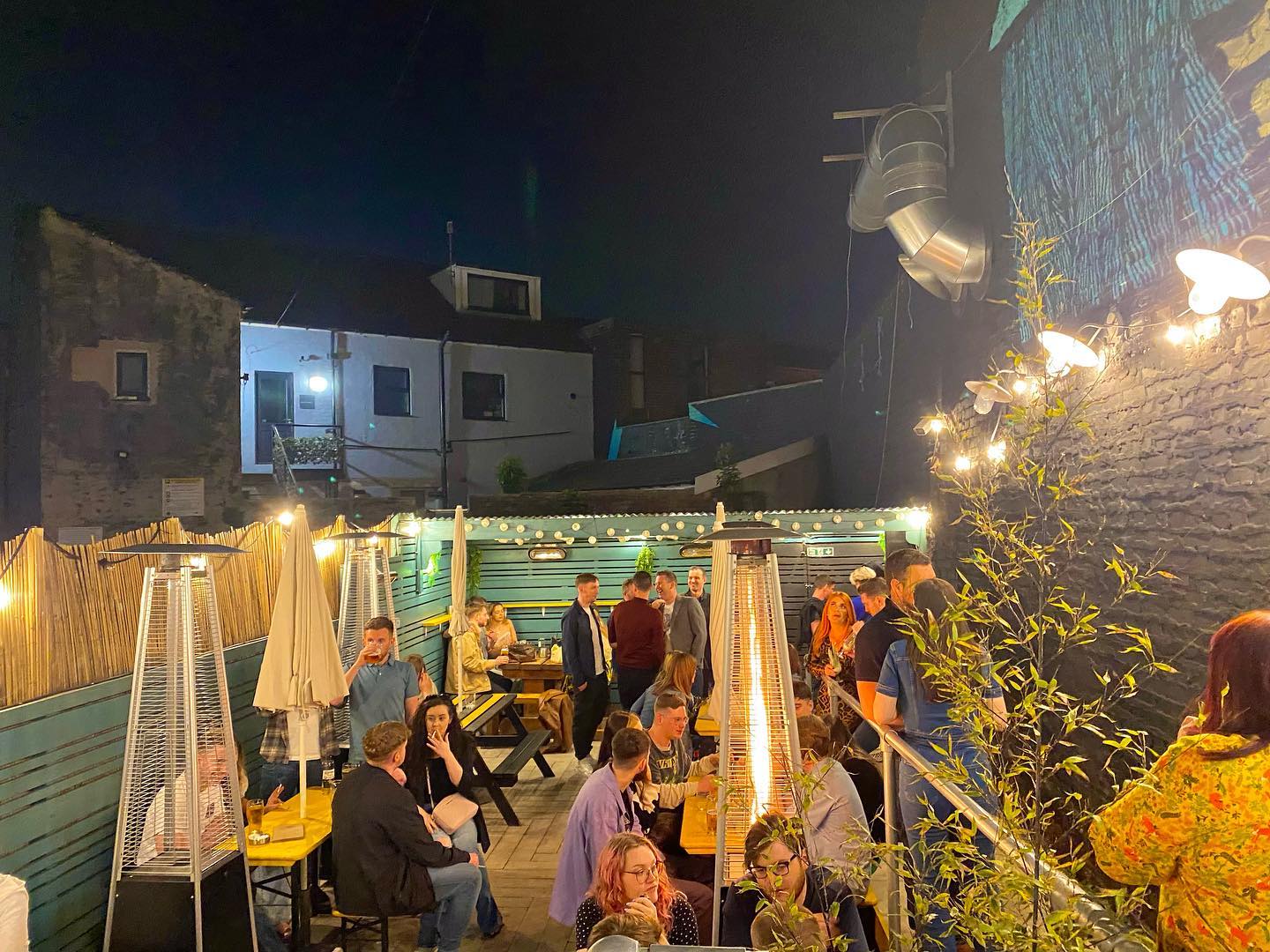 Customers in the outdoor seating are at Piña, at night.