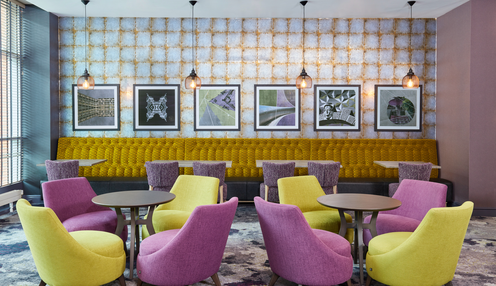 A bar area in a hotel with bright, modern furnishings.