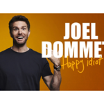 Joel Dommett is smiling and pointing at himself. Next to him it says 'Joel Dommett - Happy Idiot'.