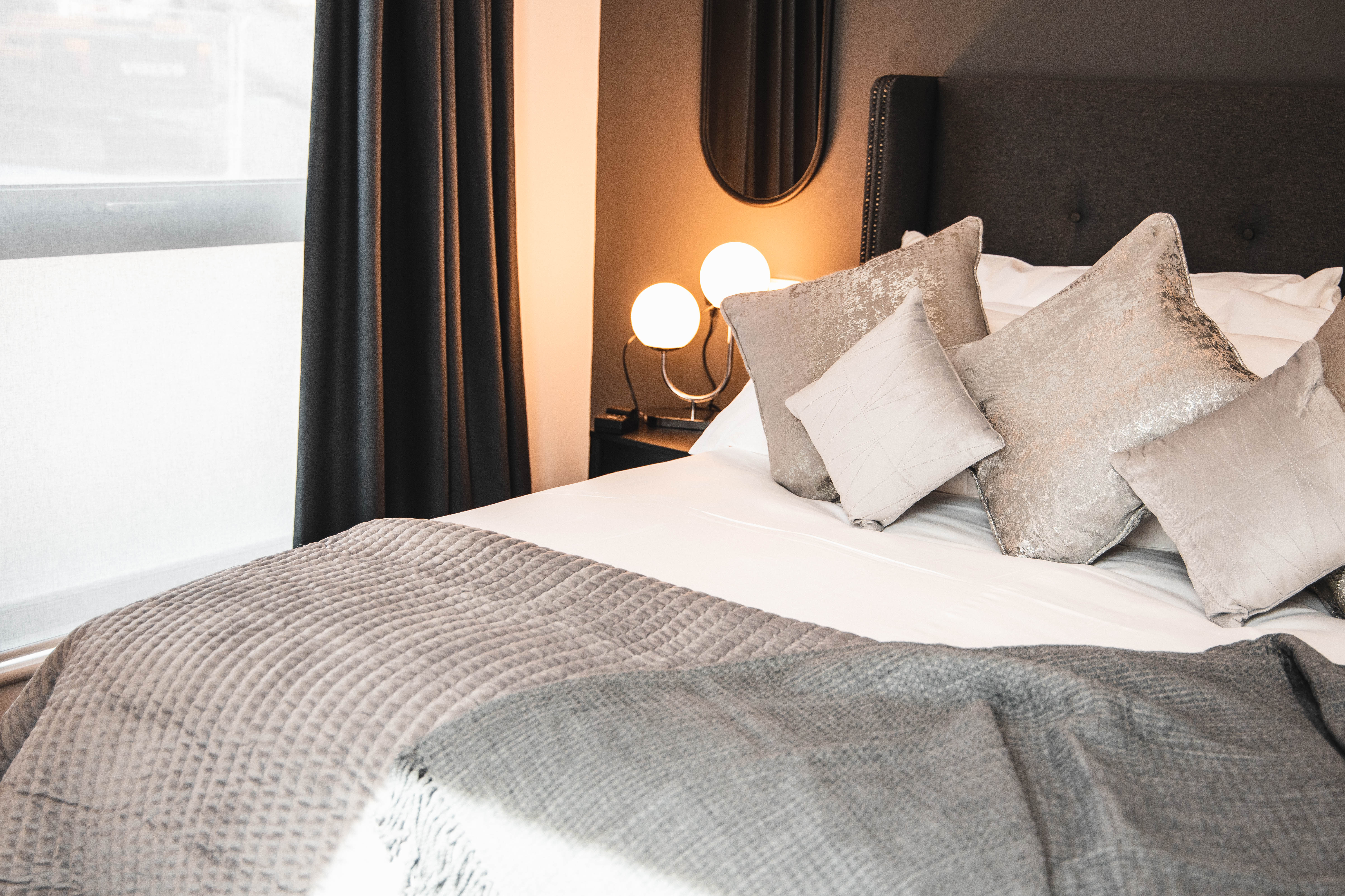 A double bed with lots od cushions.