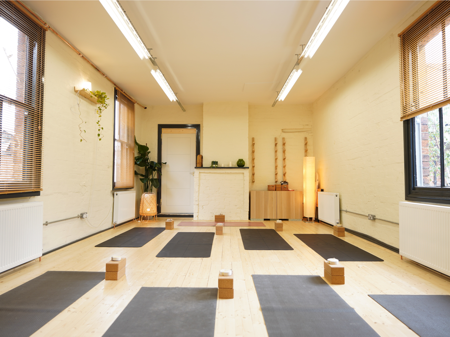 A brightly lit room at Ting Studio with mats laid out on the floor.