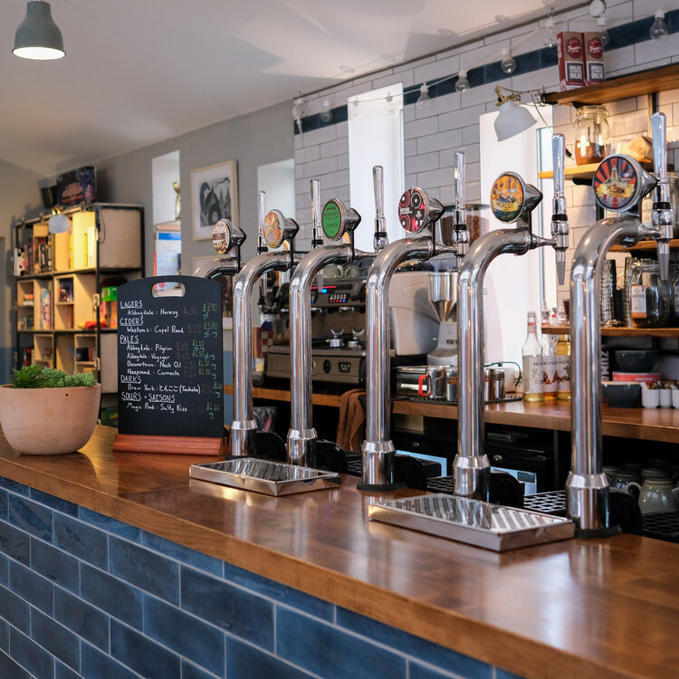 A row of drinks pumps on the counter, at The Treehouse Cafe