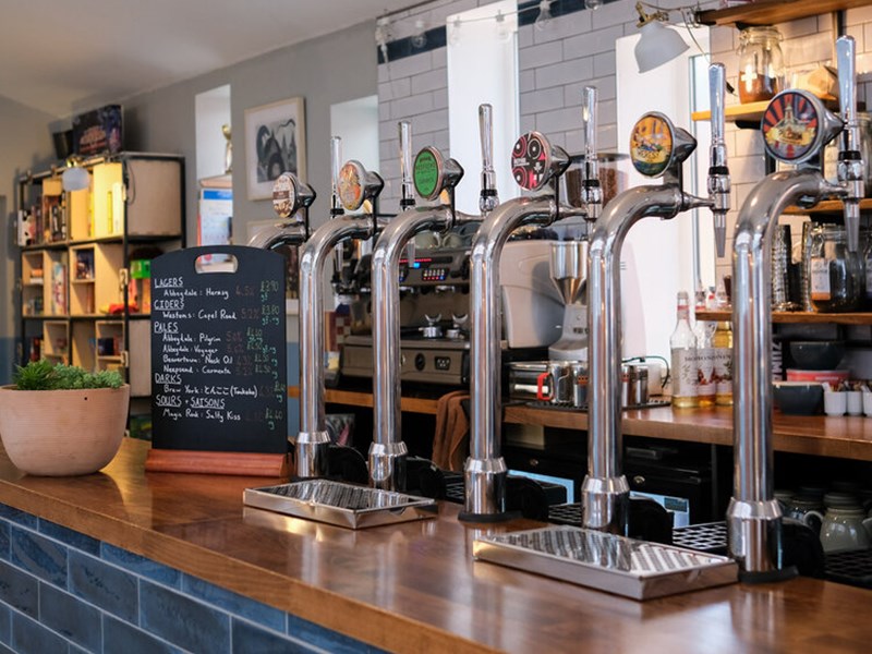 A row of drinks pumps on the counter, at The Treehouse Cafe