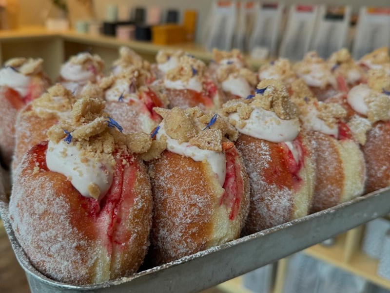 A tray of doughnuts filled with jam and cream.