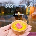 A hand holding an individual tart.