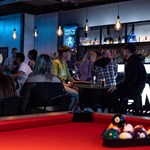 Pool table with the balls racked up at Boom Battle Bar.