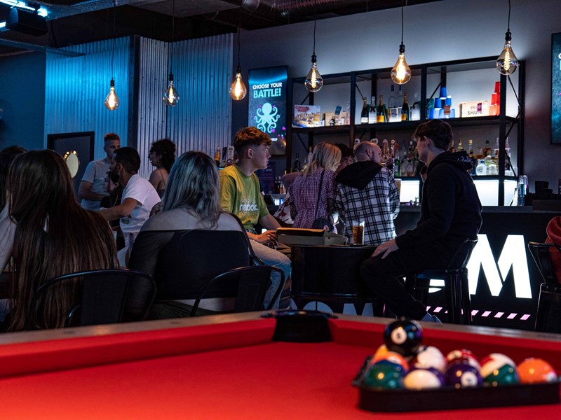 Pool table with the balls racked up at Boom Battle Bar.