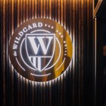 The Wildcard Bar & Grill's logo, lit up, on a wall.