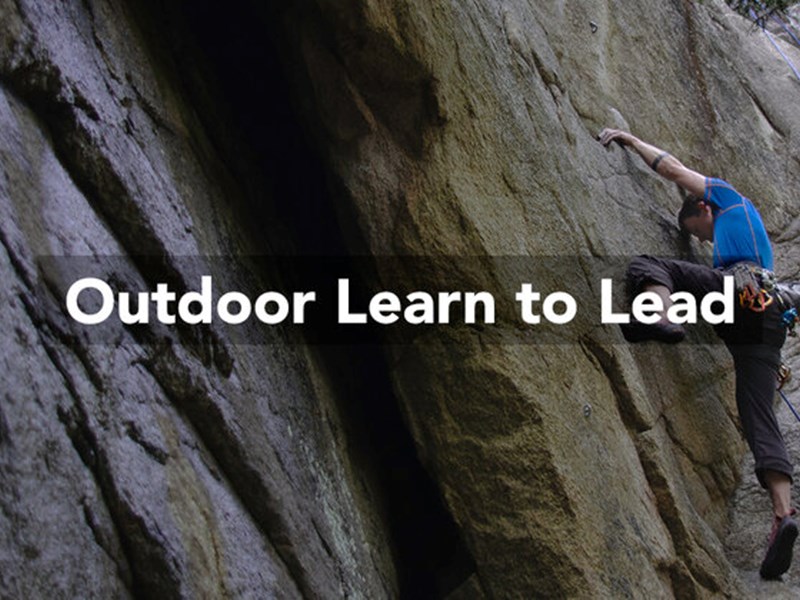 A man climbing a rocky outcrop in a wood. Over the image are the words 'Outdoor Learn To Lead'.