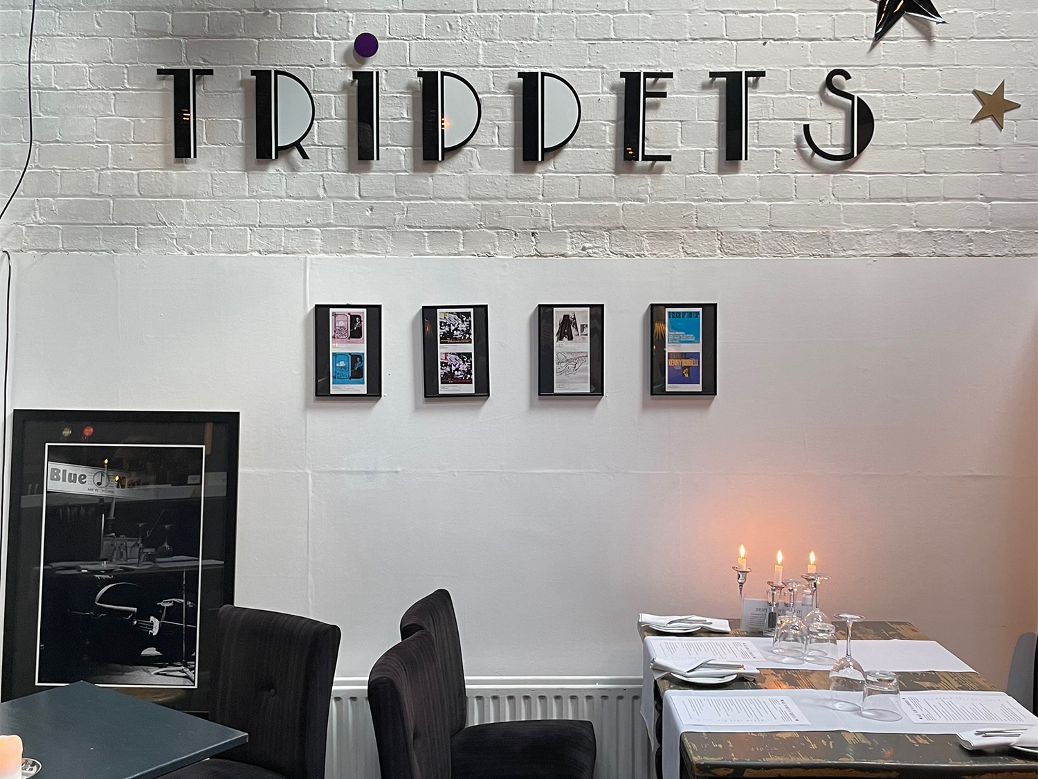 A white washed brick wall with the Trippets Lounge Bar logo on it.