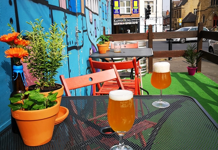 A table outside Jabbarwocky, with glasses of beer and pot plants.