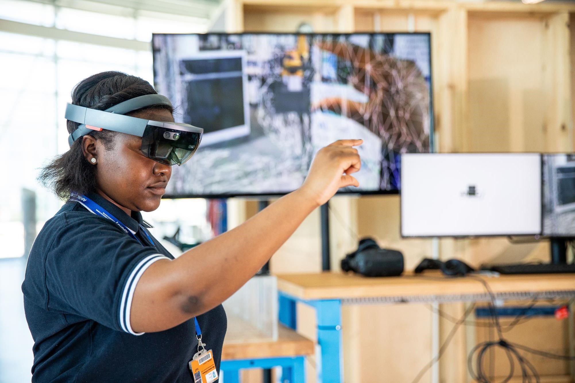 A female nurse uses a headset and enhanced-reality technology. 