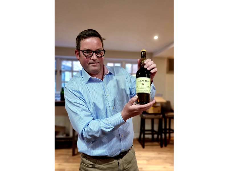 Islay Distiller David Wood holding a bottle of single malt whiskey.