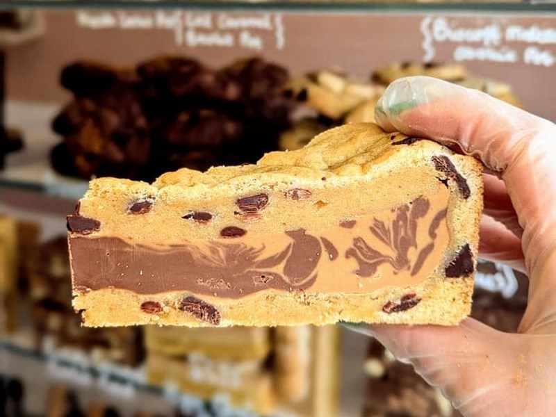A hand holding a slice of cake/ brownie.