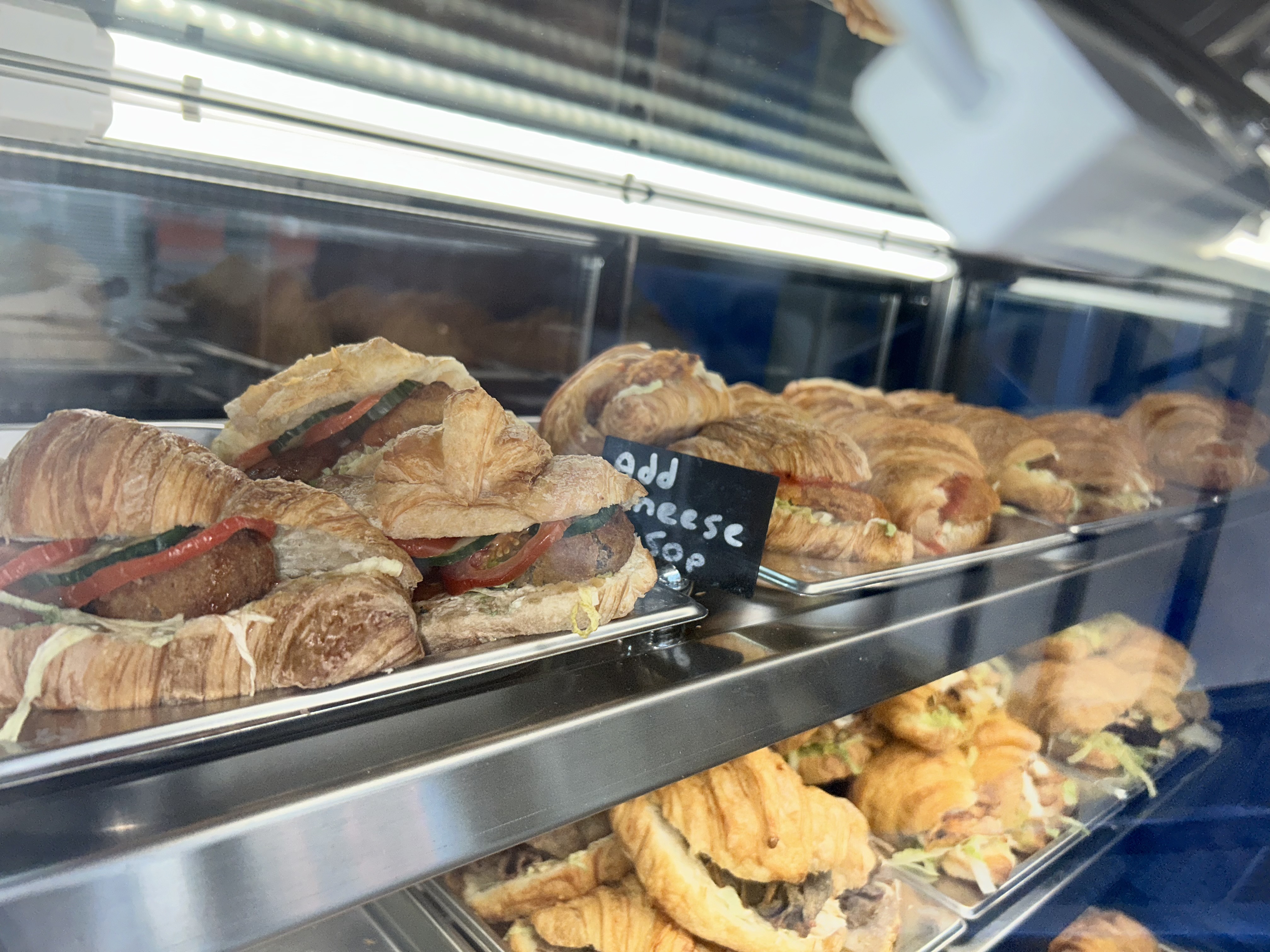 a close up of some of the filled croissants in a glass display