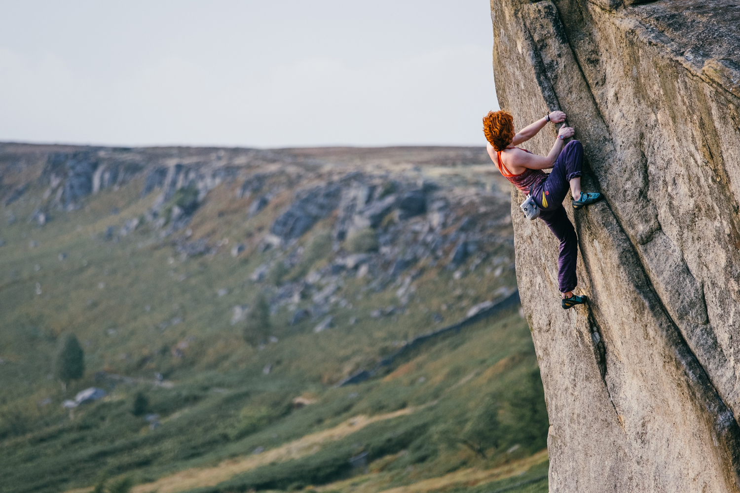 A climber on a gritstone cliff face.
