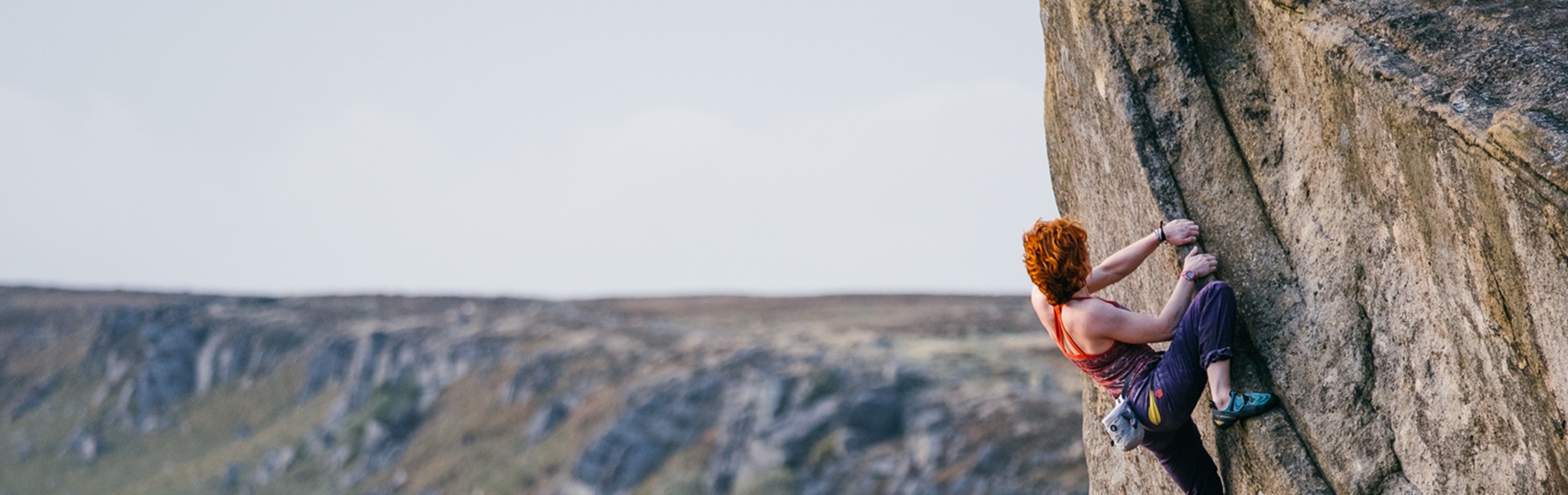 A climber on a gritstone cliff face.