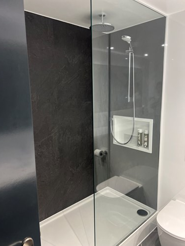 Bathroom with a large shower and a glass partition.