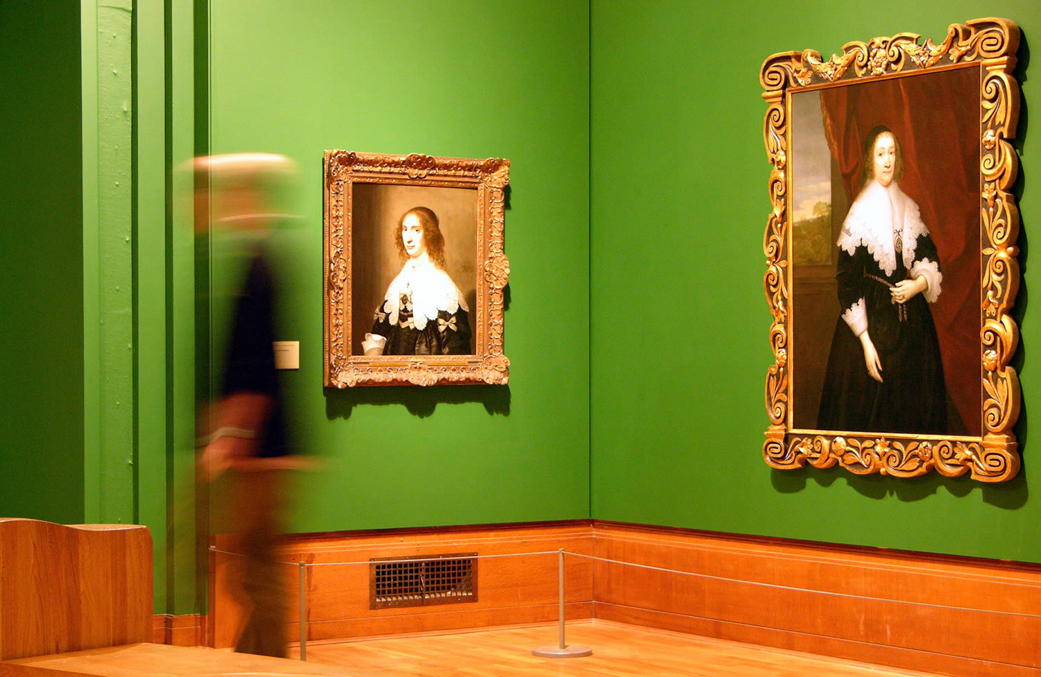 Inside Graves Gallery awoman walks past a painting.