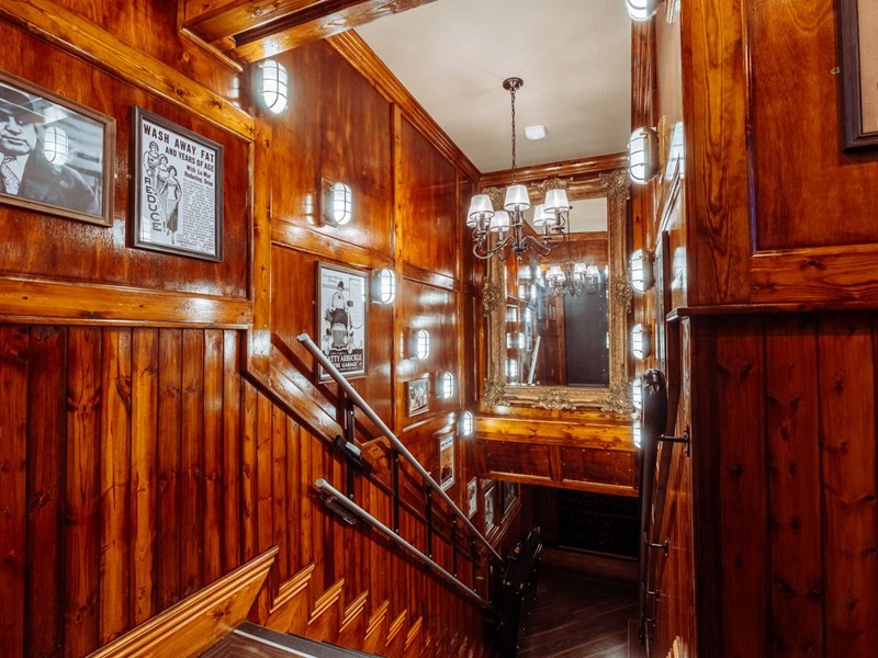 Wood panelled stairs heading down into Capone's Speakeasy.