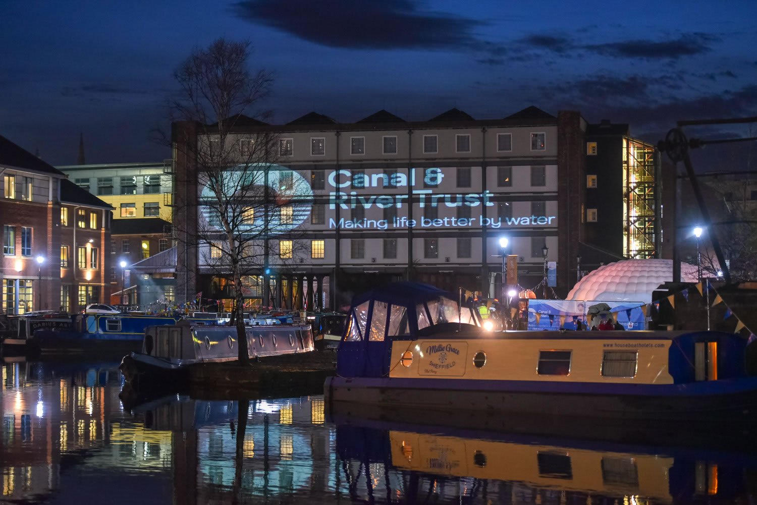 The canal basin and surrounding buildings lit up at night at Victoria Quays.