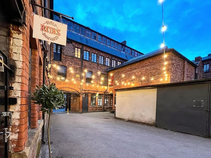 The exterior of Lovely Rita's Bakehouse at night, lit up by strings of lights.