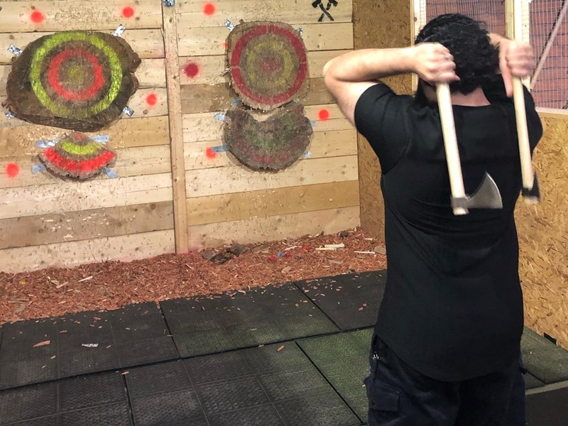 A person throwing two axes at targets in Battle Axe Sheffield.