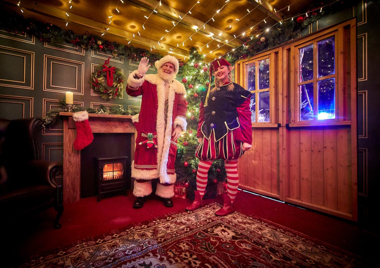 People dressed as a cheery Santa and an elf inside the festive Grotto at Meadowhall's Magical Winterland 