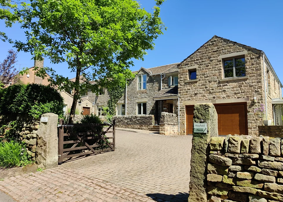Exterior view of The Clough, a traditional building set in a scenic rural area.