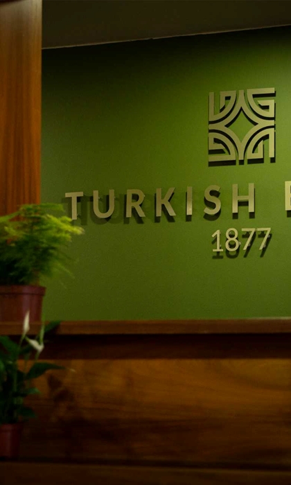 Spa 1877 sign on a wall with plants