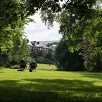 Two people sat in camping chairs, enjoying the sunshine, in Meersbrook Park.