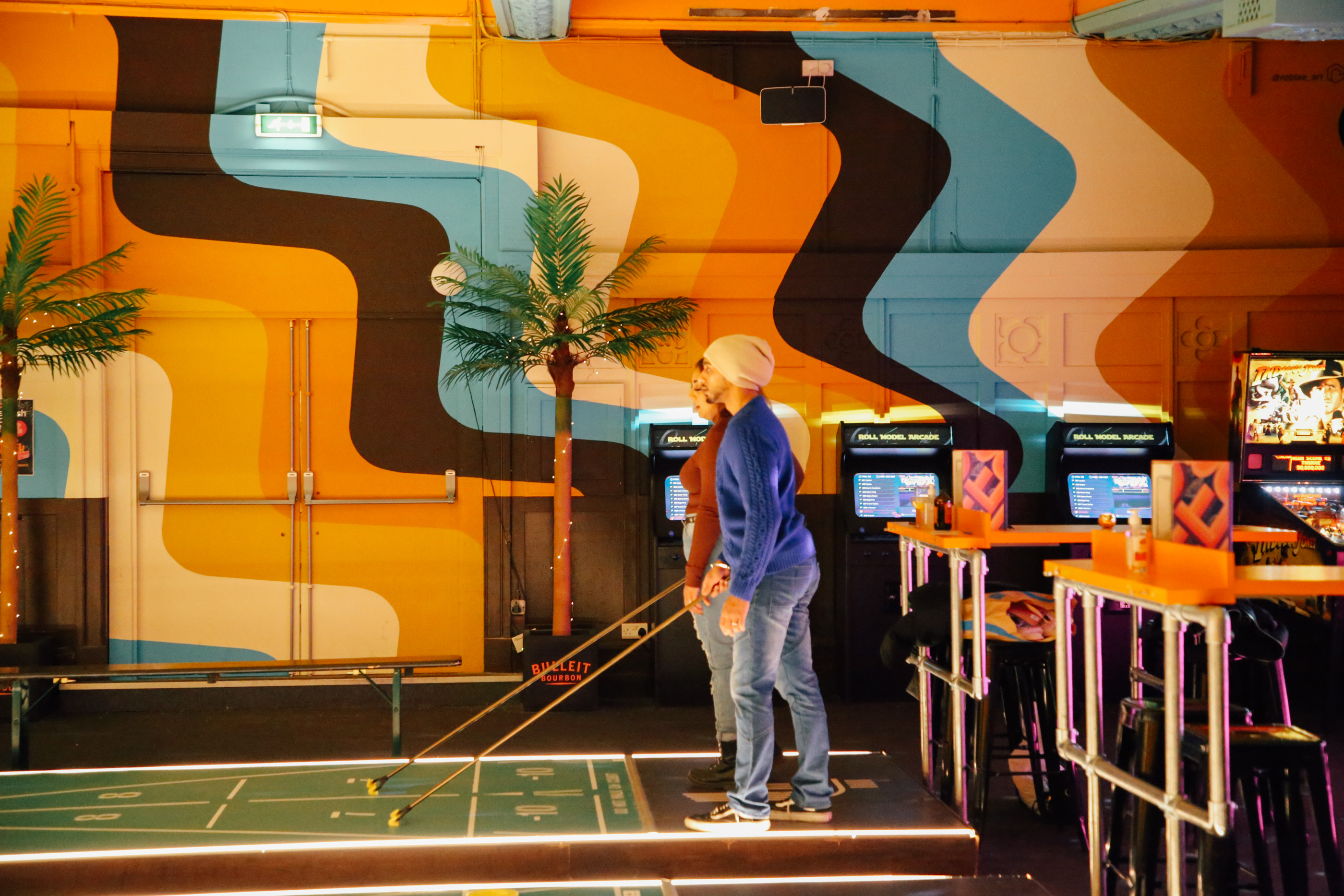 People playing indoor shuffle board at Shuffle Shack in Sheffield.
