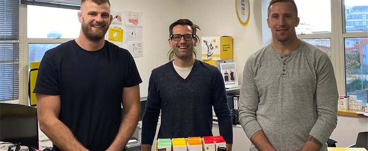 Three men stood in an office.