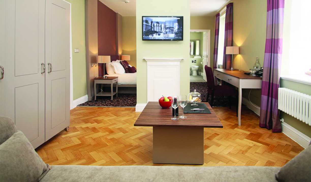 Bedroom with a comfortable living area featuring a sofa and coffee table.